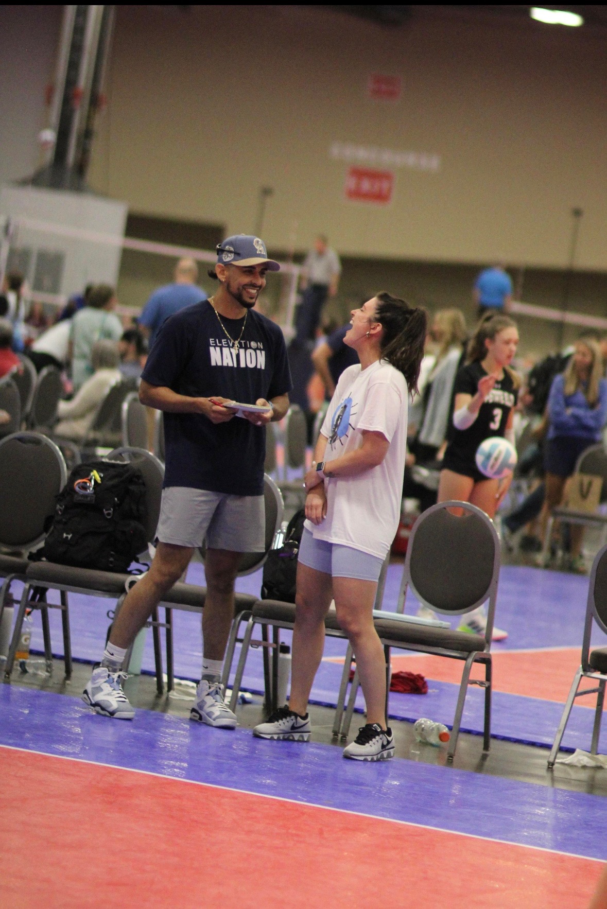 Coach Sam and Coach Courtney coaching together at a volleyball event